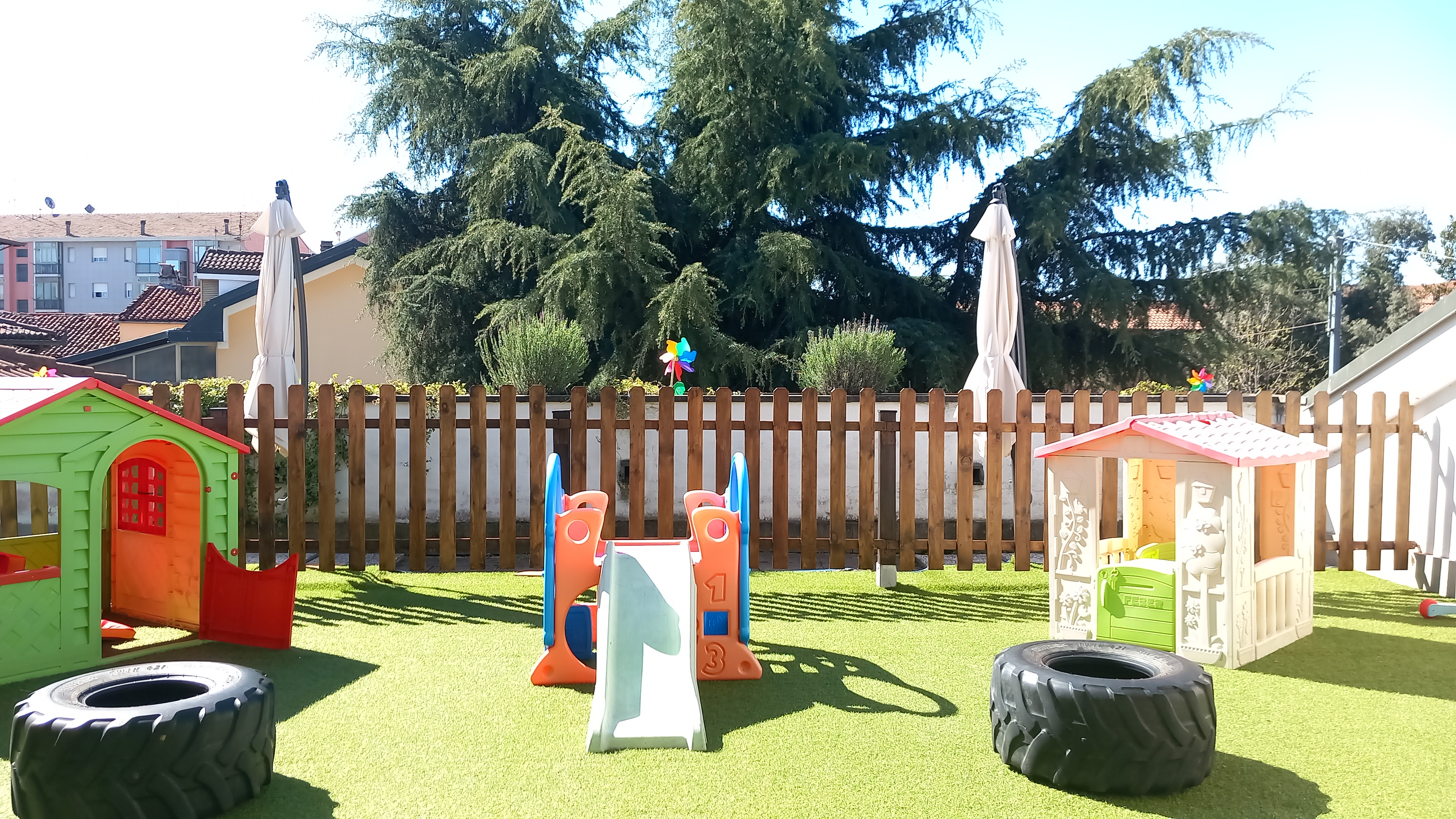 Struttura da gioco in legno con scivolo in un giardino verde