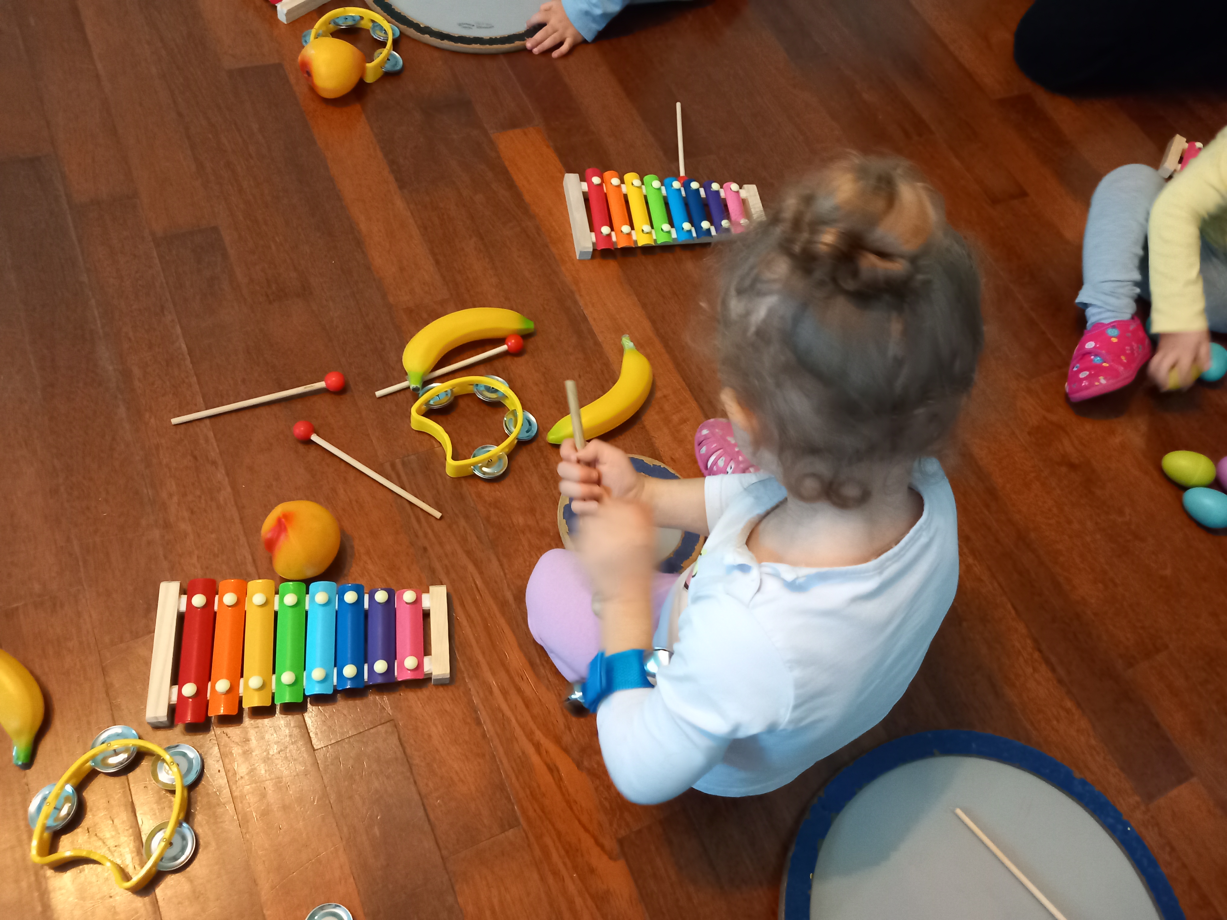 Bambini suonano maracas in una colorata aula prescolare